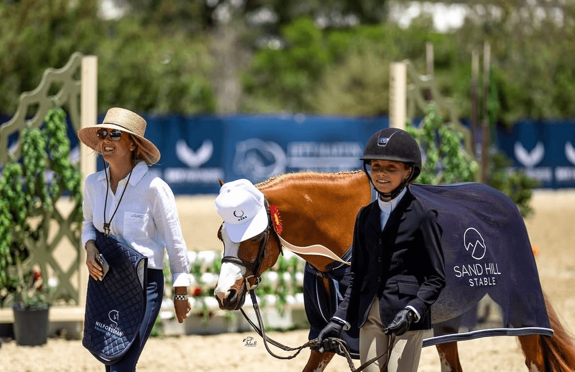 A Zeppelin Farms trainer coaching a rider ringside before a class